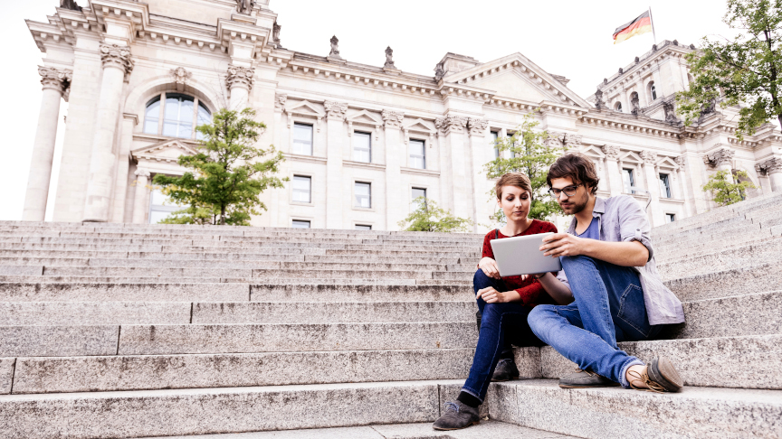 Studierende mit Tablet-PC auf den Stufen des Berliner Reichstags.